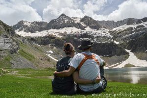Pareja disfrutando de las vistas del impresionante ibón de Sabocos en el Valle de Tena, Pirineos