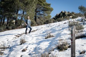 Hombre ascendiendo una ladera con nieve en la subida hacia el Cancho de la Cabeza desde Patones
