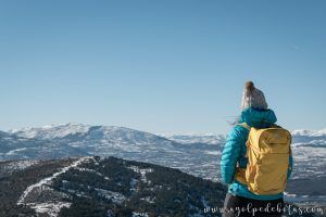 Mujer de espaldas con una mochila de montaña admirando las vistas de la Sierra de Guadrrama