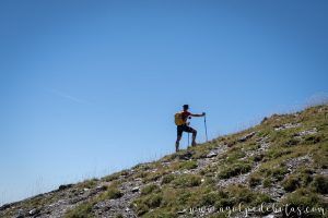 Silueta de un montañero subiendo hacia una cima