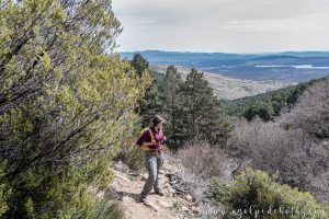 Mujer mirando el paisaje en mitad de una subida por un sendero