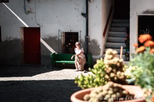 Mujer sentada en un patio interior en el pueblo de Navia de Suarna en Galicia