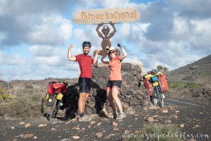 Pareja con bicicletas junto al cartel del Parque Nacional de Timanfaya en la isla de Lanzarote