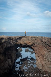 Persona sobre una arco de piedra con el mar de fondo en la isla de Tenerife