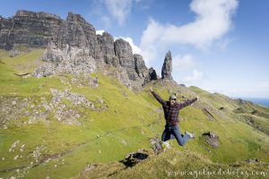 Hombre saltando frente a los pinaculos de Old Man of Storr