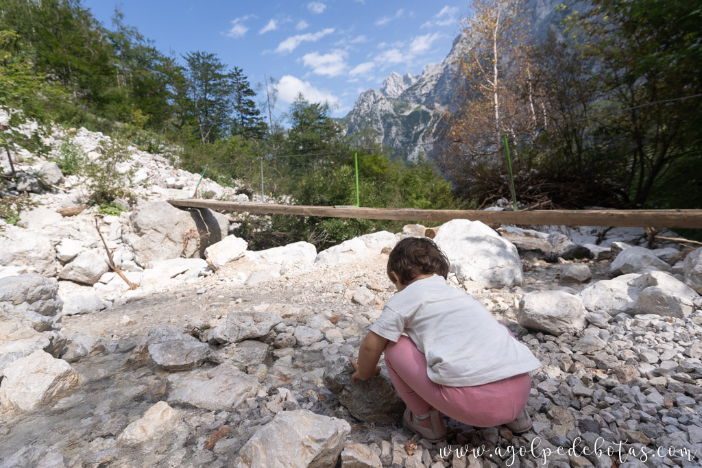 Bebé jugando con las piedras de un río en Eslovenia