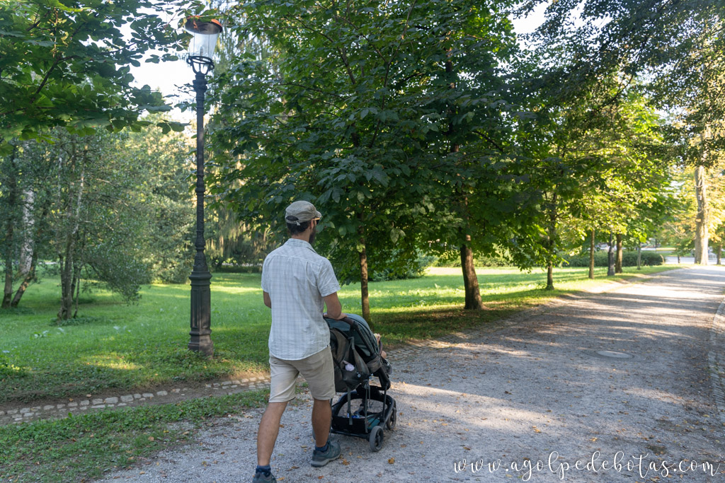 Hombre con un carrito de bebe paseando por el parque Tivoli en Liubliana