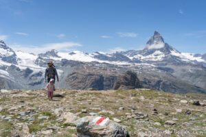 Padre e hija caminando por un sendero con los Alpes suizos de fondo, y la montaña Matterhorn como gran protagonista