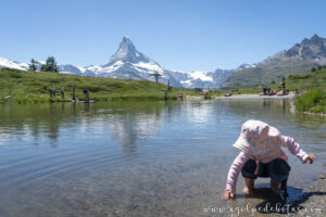 Niña jugando en la orilla de lago Leisse en Sunnegga