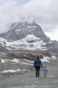 Madre e hija caminando hacia el Matterhorn desde Trockener Steg, ruta de senderismo en Suiza.