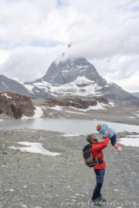 Padre e hija jugando frente al Matterhorn desde Trockener Steg, ruta de senderismo en Suiza.